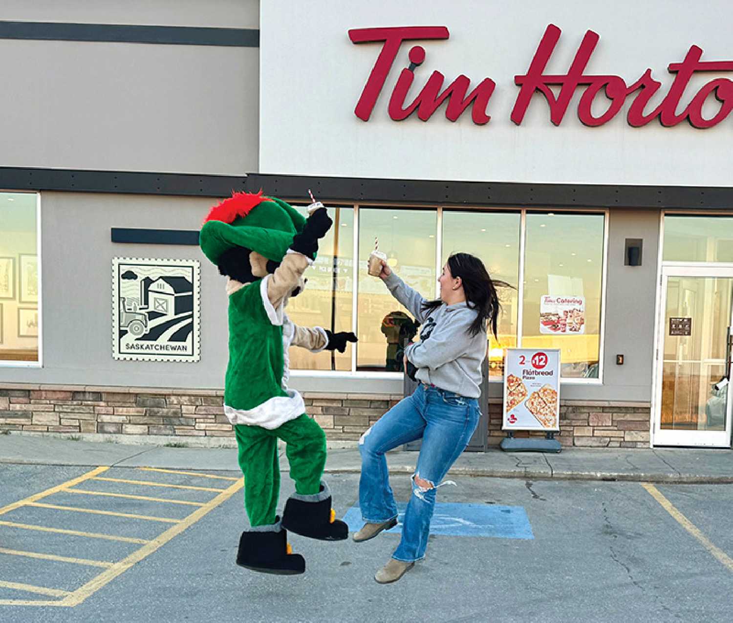 Students from McNaughton film a video promoting the Holiday Smile Cookie Campaign in the parking lot of Tim Hortons in Moosomin.